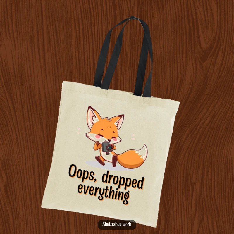 Funny Tote Bag depicting a fox character tripping while trying to get a shot, ideal for carrying photography essentials with a humorous, relatable twist.